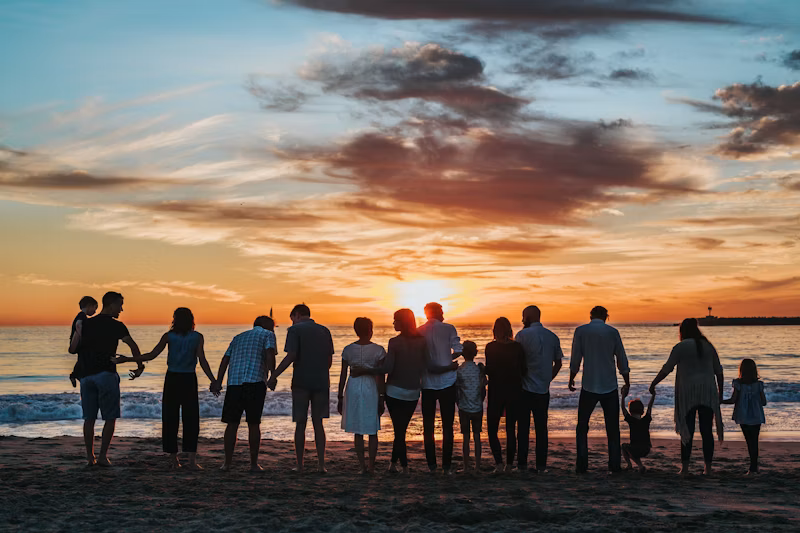 Family holding hands on a beach at sunset